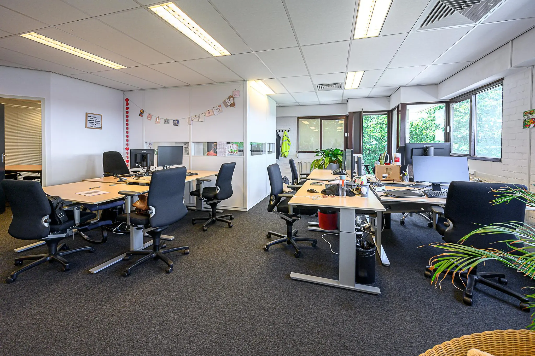 Modern kantoorinterieur met meerdere bureaus, computers en bureaustoelen in een open werkruimte bij De Linie.